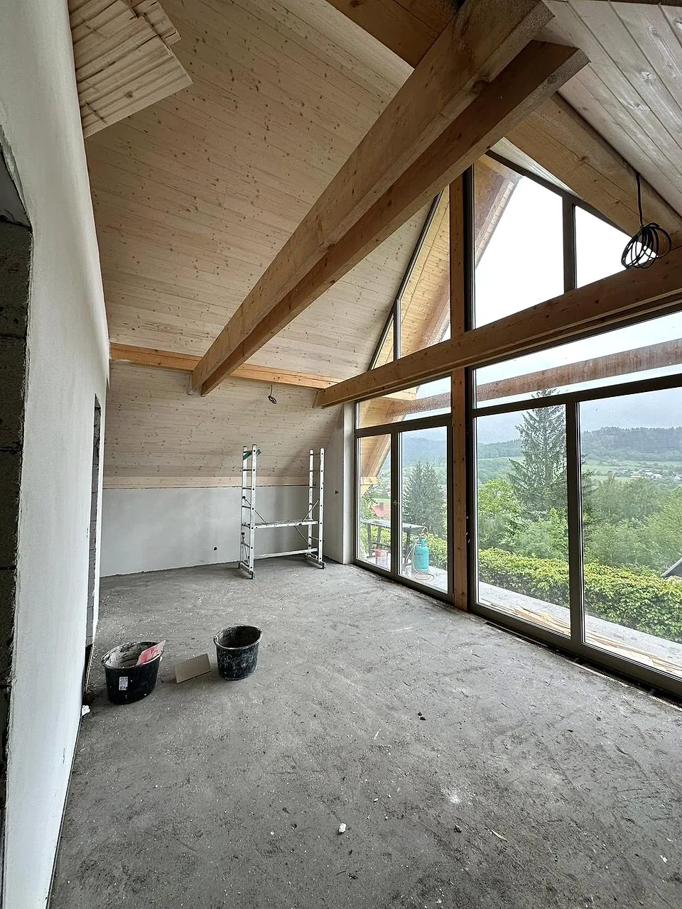 Detail dřevěné konstrukce a prosklení v interiéru chaty