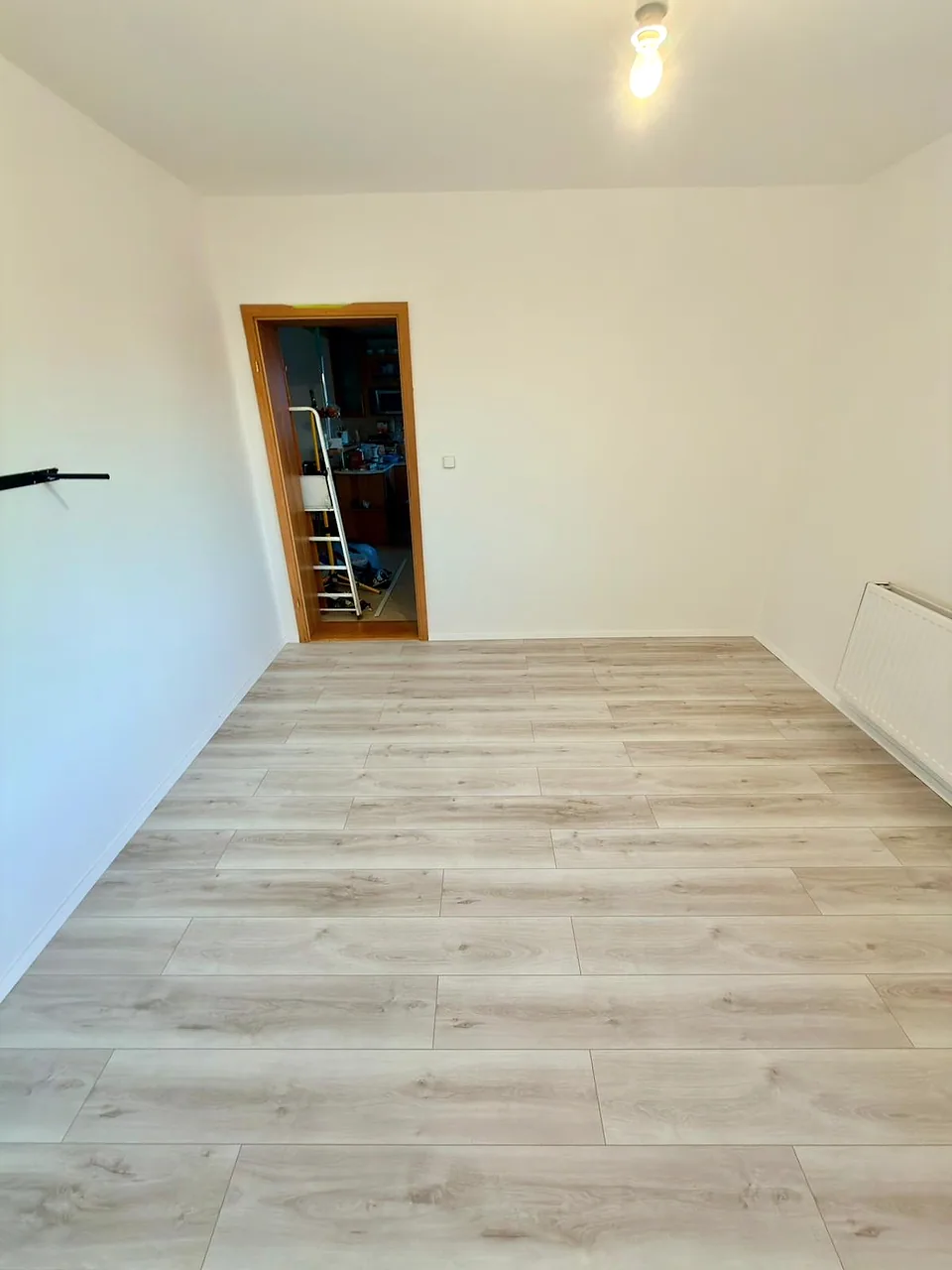 Dokončená stěna a podlaha v rekonstruovaném pokoji